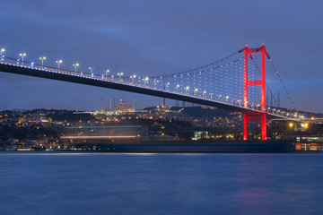 Fototapeta na wymiar Dusk over the First Bosporus Bridge Crossing the Bosphorus or Bosporus Straits Istanbul Turkey. Büyük Çamlıca Camii Mosque and Beylerbeyi Palace are visible .