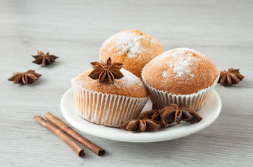 Tasty muffins on a plate ready to eat. Cinnamon sticks and star anise.