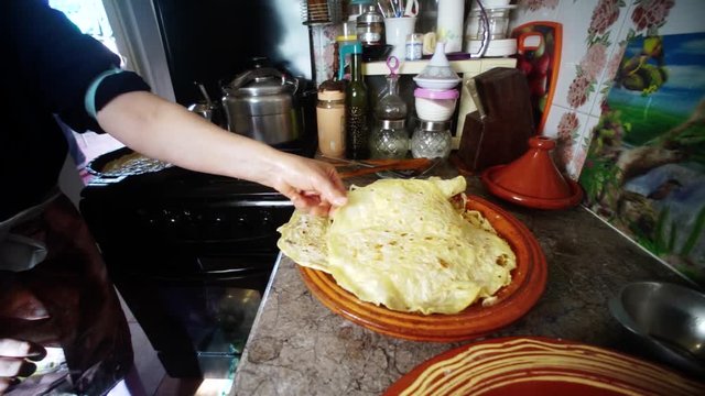 The most traditional Moroccan dishes. Moroccan woman put the cooked bread on a large traditional bowl.  making Rfissa