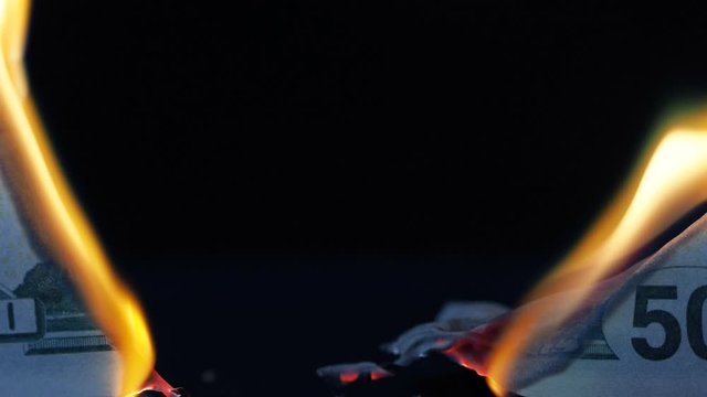 Burning 50 ten-dollar bill. Financial crisis. Money banknote on a black background, burning and Smoking, natural shooting