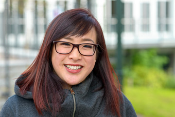 Happy young Asian woman smiling at camera