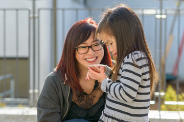 Small little girl playing with a mobile phone