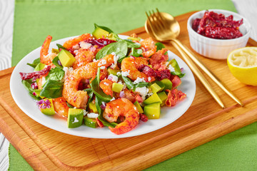 shrimp avocado spinach salad on a plate