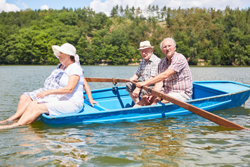 Aktive Senioren rudern im Boot auf dem See