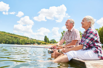 Glückliches Senioren Paar beim Angeln am See