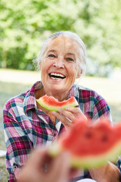 Fr&ouml;hliche Senior Frau beim Melone essen