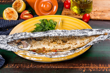 Mackerel cooked with lemon in foil served on a plate