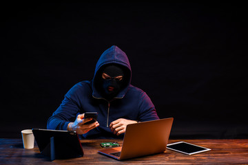 young dangerous hacker bandit engaged in crime, don't afraid of strangers, entered the room and hack laptop system, password. cyberattack nowadays. isolated in dark smoky space