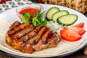 Grilled pork steak served with fresh vegetables