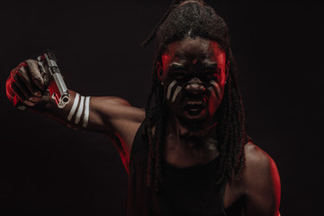close-up of angry furious black man isolated over black background, young male with dreadlocks on head, screaming at camera, dangerous thug with red neon rays on face
