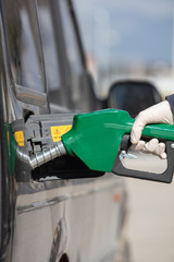Pumping gas at gas pump. Closeup of man pumping gasoline fuel in car at gas station.