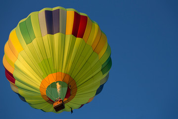 Fototapeta premium Isolated Skyward View of Hot Air Balloon Against Clear Blue Sky 