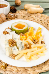 Cheese plate with different types of cheese on a white plate