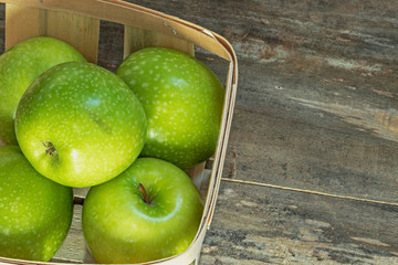 Pommes Granny Smith dans une cagette sur fond de bois
