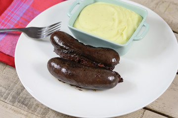 boudin noir cuit et purée dans une assiette