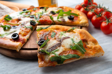 Deliziosa pizza con rucola, acciughe e olive 