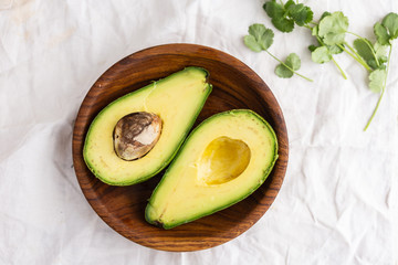 Big avocadp halves in a wooden bowl