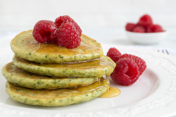 vegetarian spinach pancakes with raspberries and honey.