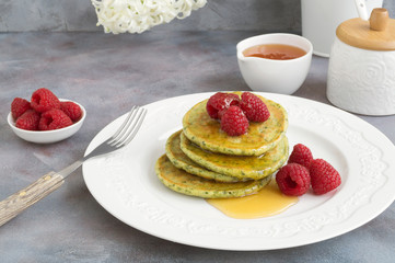 vegetarian spinach pancakes with raspberries and honey.