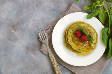 vegetarian spinach pancakes with raspberries and honey.