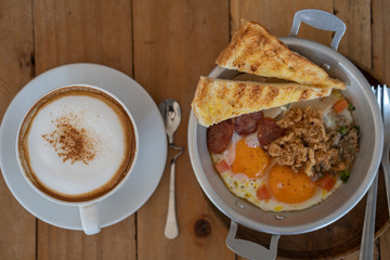Cup coffee, Egg Fried with Pork and sausage on wooden table.