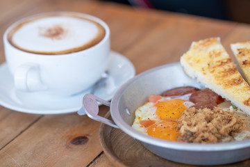 Egg Fried with Pork and sausage on wooden table.