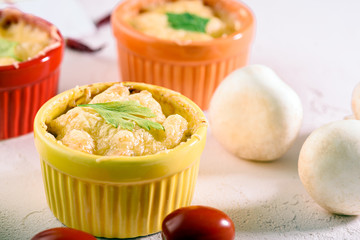 cheese casserole with mushrooms in colorful cocoanuts on white background