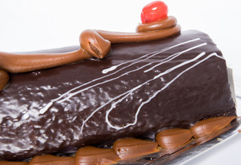 Tarta brazo gitano de chocolate sobre fondo blanco