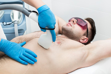 Fototapeta na wymiar Laser hair removal procedure for a man in a beauty salon.
