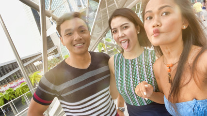 Happy young asian friends enjoying city view outdoor