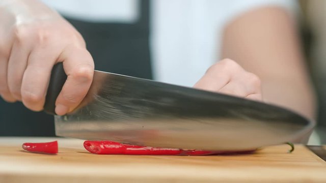 Close up female kitchener hand cutting red spice pepper. Shot on RED Raven 4k Cinema Camera