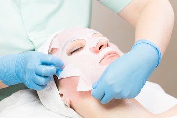 Fototapeta premium Procedure female cosmetic mask and chistak face in a beauty salon.