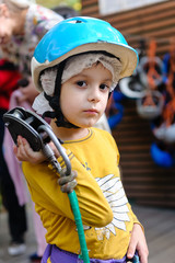 Fototapeta na wymiar Portrait of a five-year-old boy in a climbing helmet in a steam park. Concept - safety in a rope park.