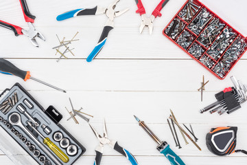 Frame of tools with tool boxes on white wooden surface