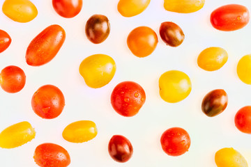 Texture of colorful cherry tomatoes (red, garnet and yellow), fresh and raw. With water drops Isolated on white background.