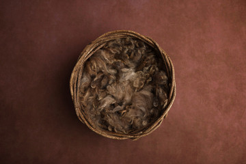 Newborn photography digital background prop. wicker basket with brown fur on a painted canvas.