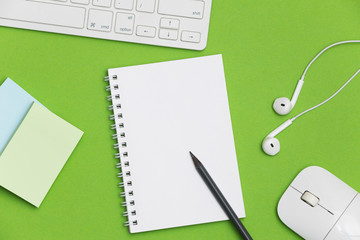 Blank spiral notebook and pencil on green background. Top view with copy space for input the text.	