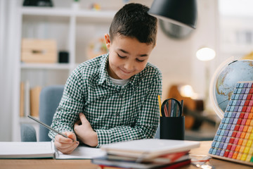 Cute little boy doing homework. Child learning foe school.