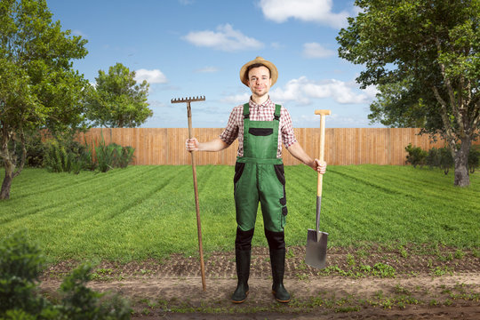 Smiling gardener ready for work in a green backyard
