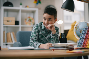 Cute little boy doing homework. Child learning foe school.