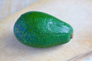 A ripe avocado on a wooden board on the table