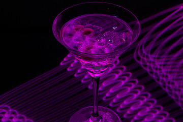 Long exposure martini glass with ice and olives
