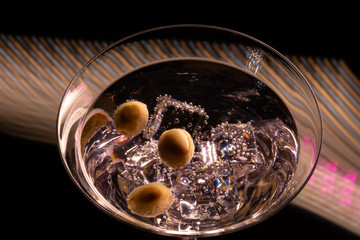 Long exposure martini glass with ice and olives