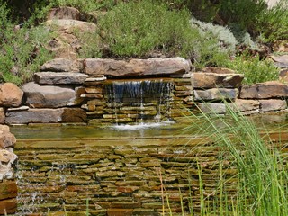 Scenic view of a small waterfall in a landscaped garden