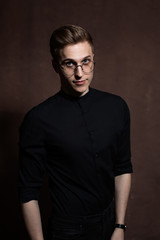 Obraz premium Man in round glasses and a black shirt.