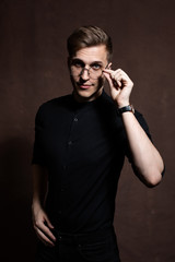 Obraz premium Man in round glasses and a black shirt.