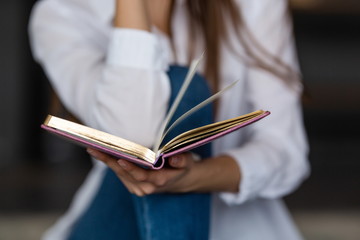 Girl reading plans in a notebook holding hands close up