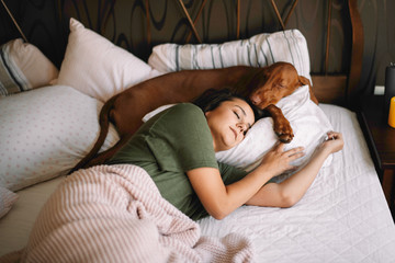 Girl with dog in bed. Best friends sleeping together. - Powered by Adobe