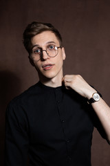 Man in round glasses and a black shirt.