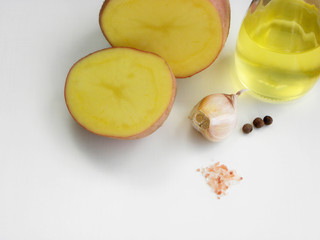 raw cut potato and spices on a white background.